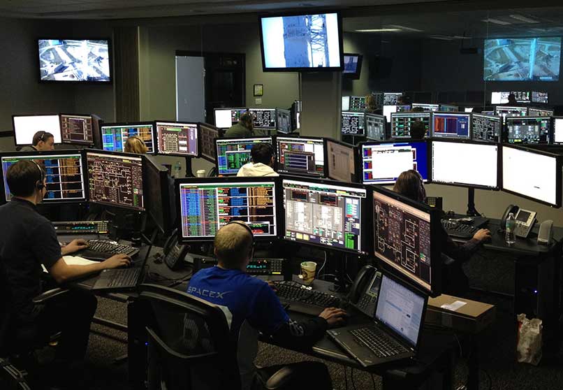 Photo of many computers and monitors in a large room.